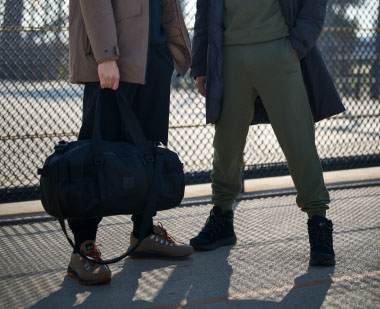 Two men with a duffel bag