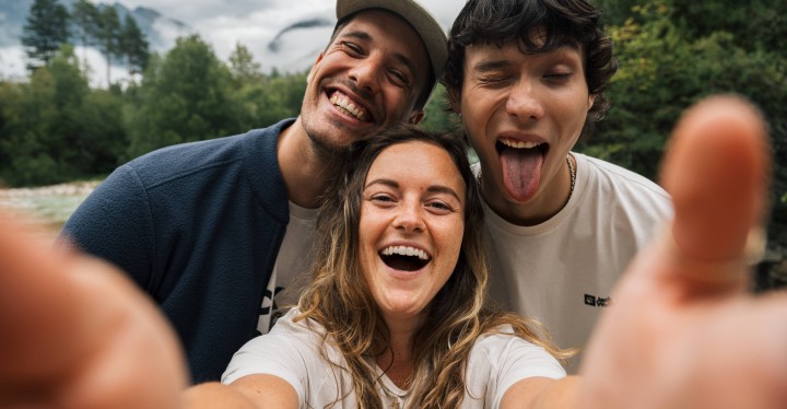 Three people laughing while taking a selfie